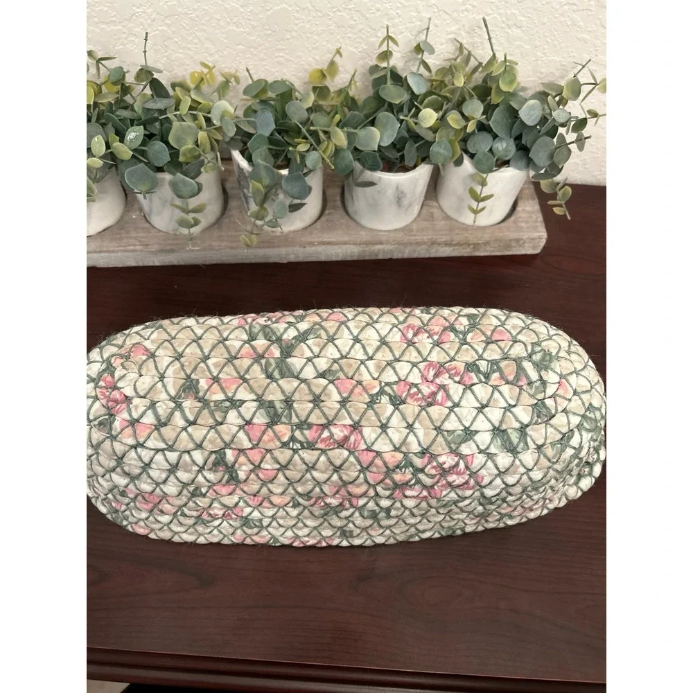 vintage oval rag rug basket features a braided, quilted design in green and pink